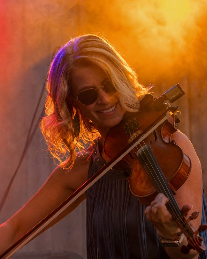 Melissa Southwick playing fiddle under stage lights